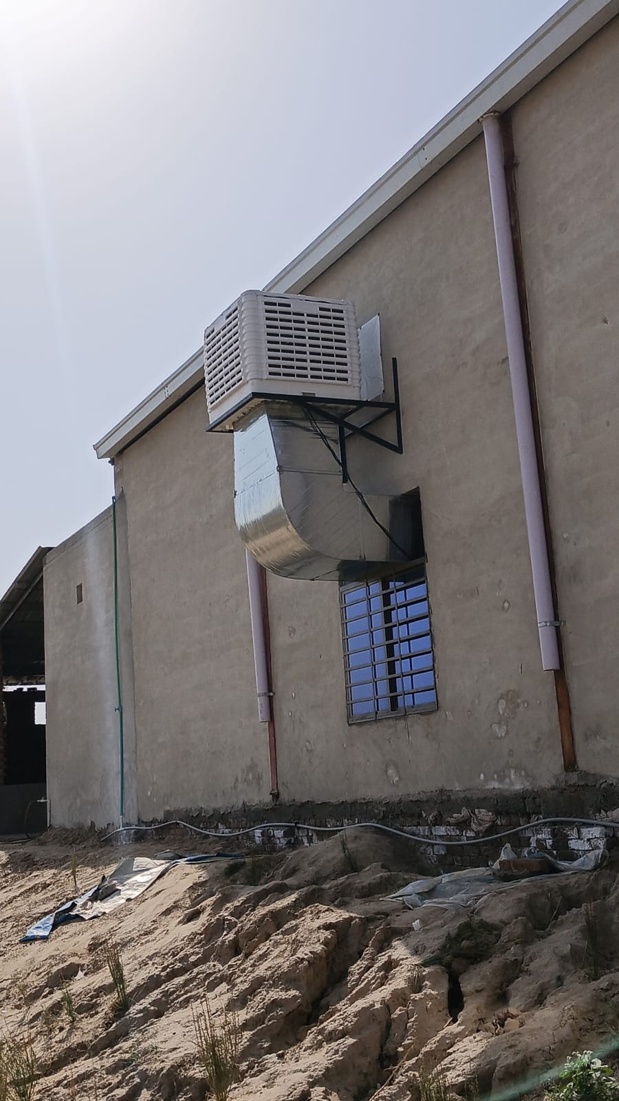 Cooler on a wall bracket ducted into a window opening